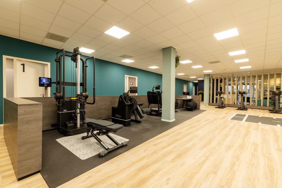 De oefen- en revalidatiezaal van Fysio Bladel met fitnessapparatuur en behandelruimtes.